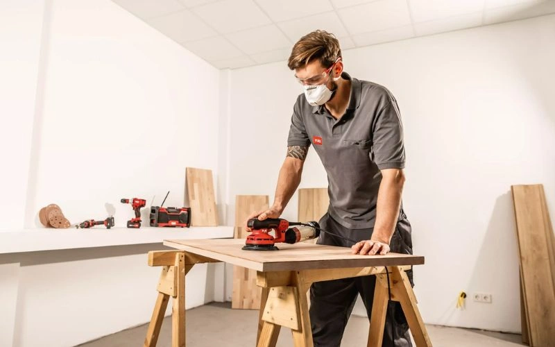 Carpenter Sanding Wooden Board